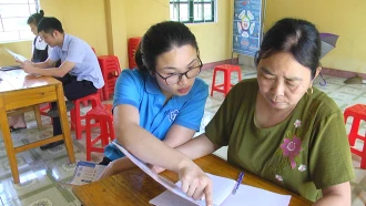 Cán bộ BHXH huyện Lục Yên tuyên truyền hướng dẫn người dân tham gia BHXH và BHYT tự nguyện