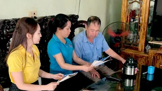 Viên chức BHXH khu vực XVII phối hợp với cán bộ bưu điện tuyên truyền chính sách BHXH tự đóng, BHYT tại hộ gia đình.