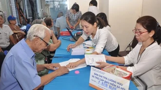 Nhân viên bưu điện thực hiện chi trả lương hưu cho người dân.