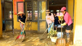 Các thầy cô giáo Trường TH &THCS Minh Chuẩn tập trung dọn trường lớp bị ngập bùn đât.