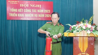 Trung tá Nguyễn Viết Chí - Trưởng Công an phường Minh Tân trực tiếp tuyên truyền, hướng dẫn người dân tổ 6, phường Minh Tân kỹ năng sử dụng bình chữa cháy. (Ảnh: Thủy Thanh)