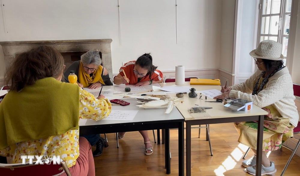 Một buổi vẽ chữ thư pháp được tổ chức ở tầng trệt của ngôi nhà, nơi thường xuyên diễn ra các hoạt động văn hóa.