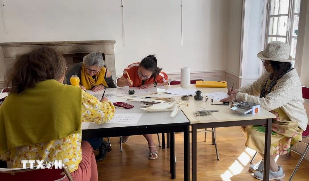 Một buổi vẽ chữ thư pháp được tổ chức ở tầng trệt của ngôi nhà, nơi thường xuyên diễn ra các hoạt động văn hóa.