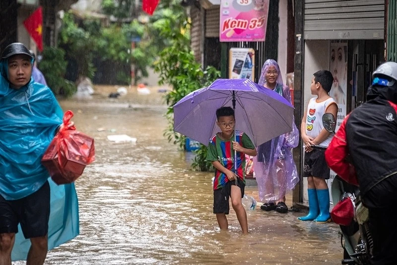 Trẻ em bị ảnh hưởng khi lũ ập về khu vực gần sông Hồng.