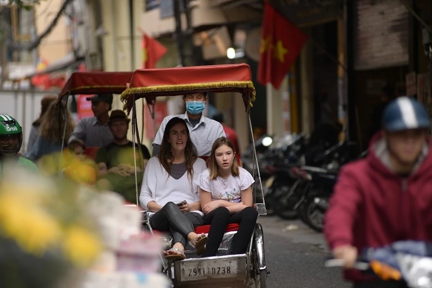 Du khách quốc tế trải nghiệm du lịch quanh phố cổ Hà Nội bằng xích lô.