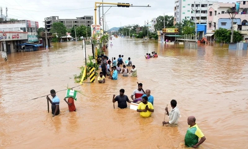 Người dân lội qua con phố bị ngập ở bang Andhra Pradesh, Ấn Độ, ngày 2/9.