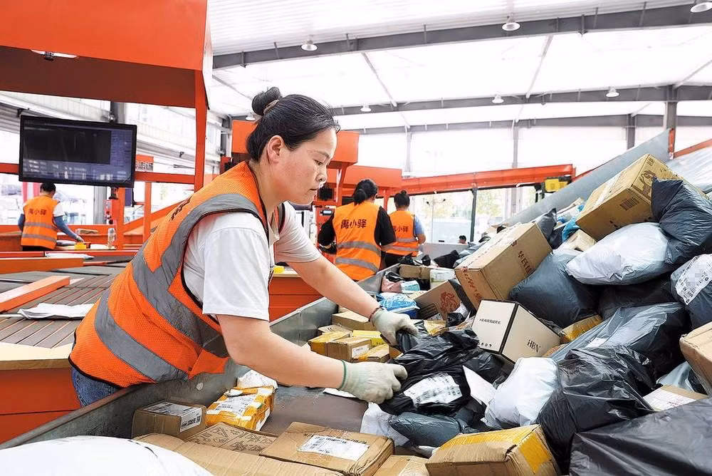 Các nhân viên tại trung tâm phân phối ở Yucheng xử lý bưu kiện với sự trợ giúp của máy phân loại.