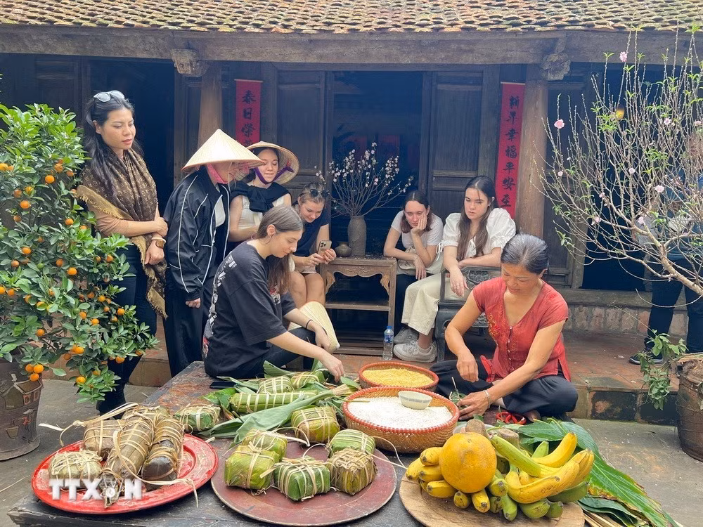Khách quốc tế trải nghiệm gói bánh chưng tại Làng cổ Đường Lâm.