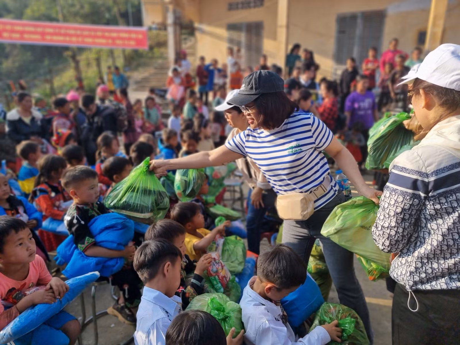 Du khách tự tay trao phần quà, sách vở học tập cho các em học sinh.