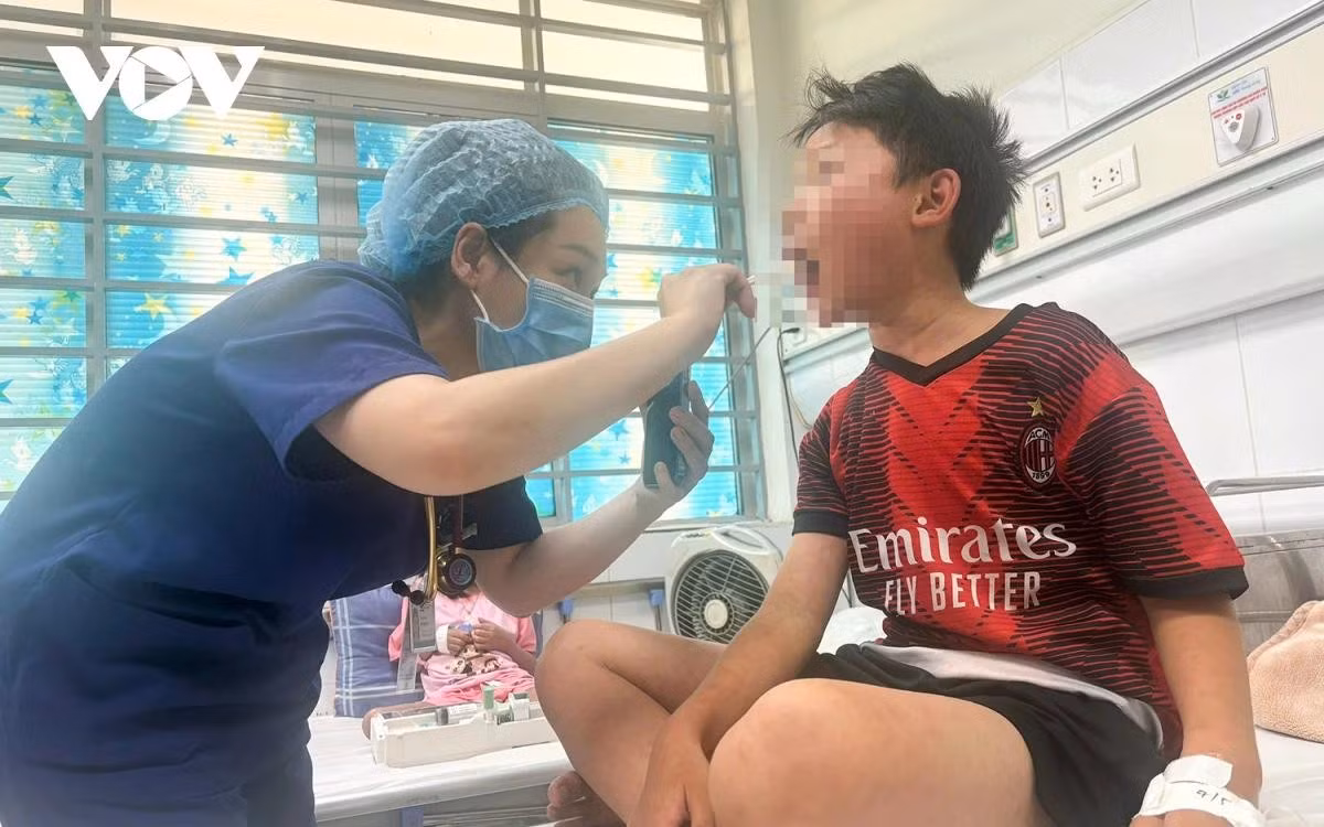 Bác sĩ đang thăm khám cho bệnh nhi Trần Phú Hào (10 tuổi, huyện Nghĩa Hưng, tỉnh Nam Định).