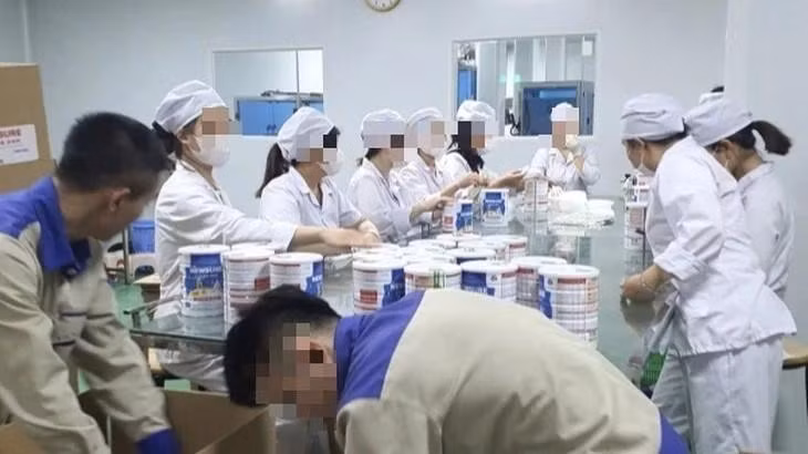 Công nhân đóng hộp thành phẩm tại cơ sở sản xuất sữa bột giả quy mô lớn vừa bị Công an thành phố Hà Nội triệt phá.