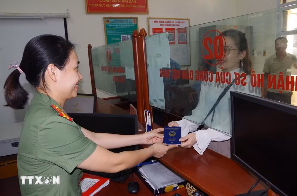 Cán bộ Phòng Quản lý xuất nhập cảnh, Công an tỉnh Hà Nam, trao trả hộ chiếu cho công dân.