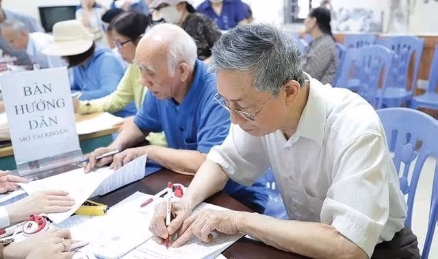 Cán bộ BHXH hướng dẫn người cao tuổi nhận lương hưu, trợ cấp BHXH qua các tài khoản cá nhân.