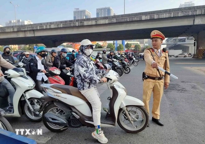 Một trường hợp vi phạm lỗi không chấp hành đèn tín hiệu giao thông bị lực lượng cán bộ, chiến sỹ đội Cảnh sát Giao thông số 7 dừng xe, kiểm tra và xử lý. (Ảnh: Phạm Kiên/TTXVN)