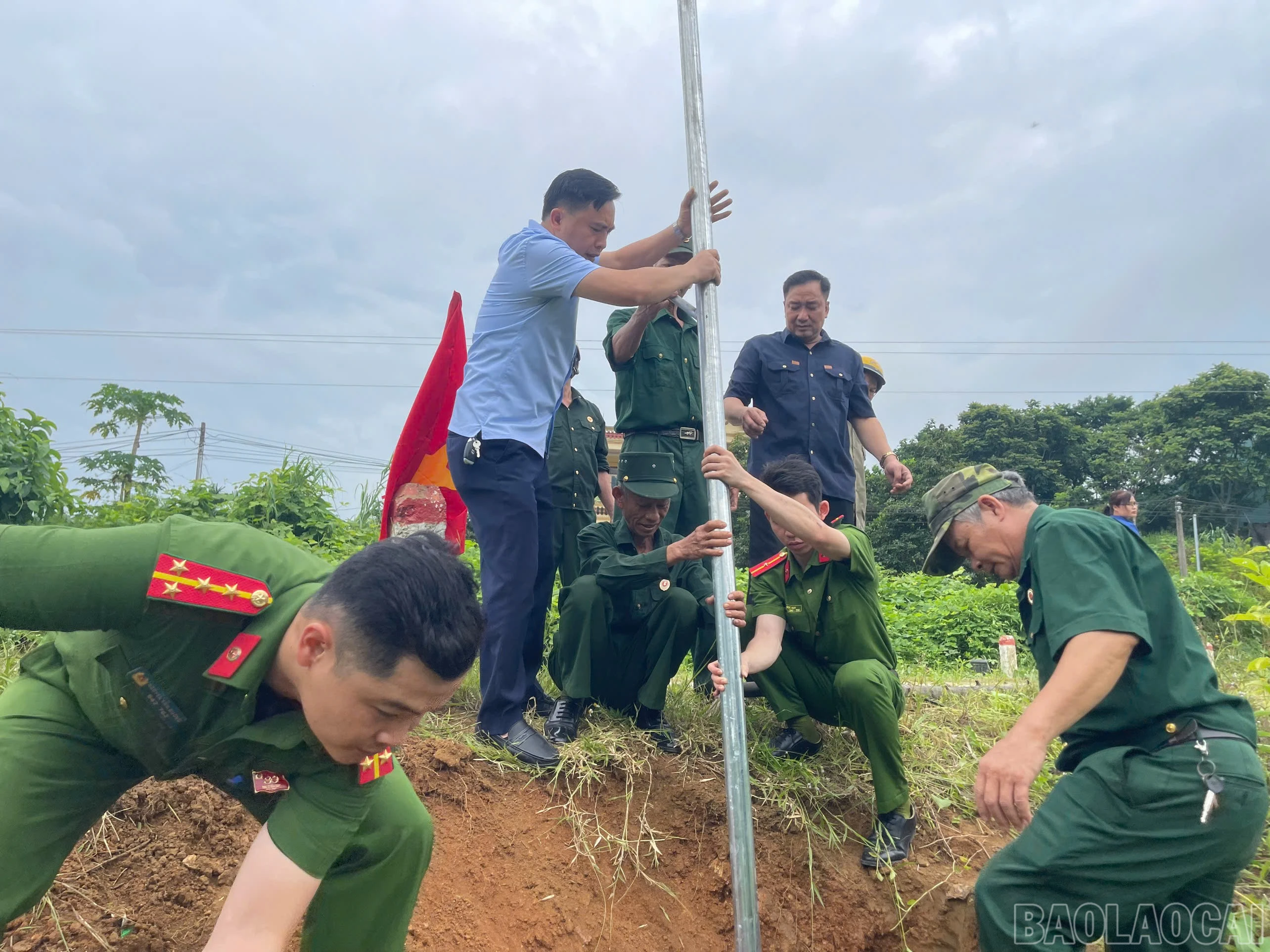 Các lực lượng tham gia dựng đèn năng lượng mặt trời trên tuyến đường tại thôn Liên Hà 5, xã Bảo Hà.
