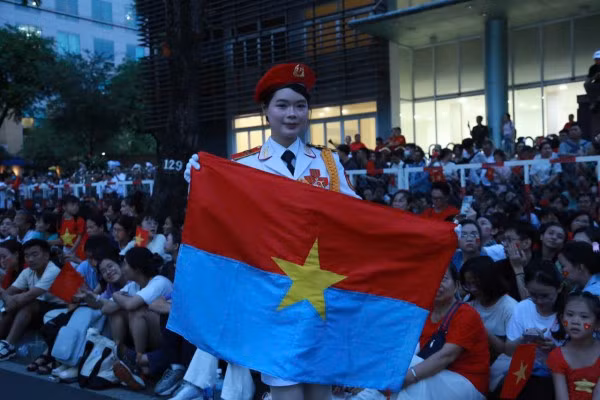 Nữ chiến sĩ xinh đẹp cầm lá cờ Giải phóng chụp ảnh lưu niệm trước giờ diễn tập.