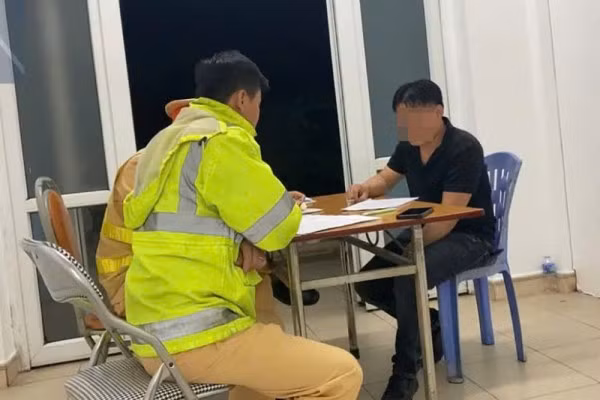 Cán bộ CSGT đường bộ cao tốc số 1 lập biên bản đối với tài xế ô tô đi ngược chiều trên cao tốc.