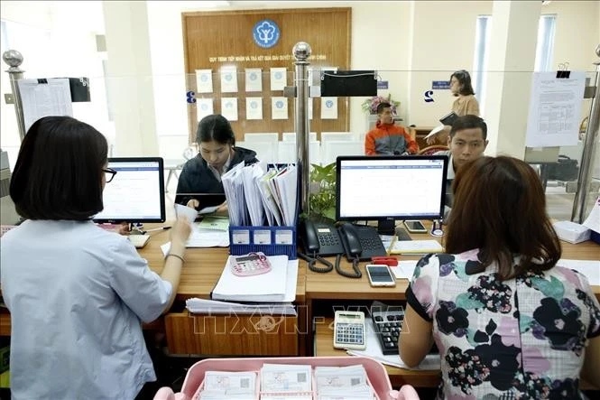 Giải quyết thủ tục hành chính tại BHXH địa phương. Ảnh: TTXVN