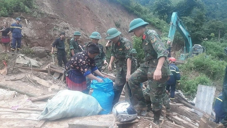 Giúp bà con thu dọn những đồ dùng trong ngôi nhà đổ sập do lở đất.