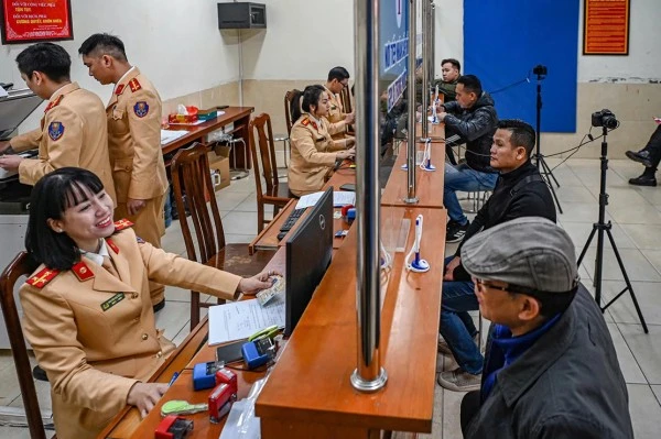 Các cán bộ Công an tiếp nhận hồ sơ cấp đổi giấy phép lái xe.