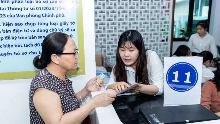 Cán bộ, công chức hỗ trợ người dân làm thủ tục hành chính.