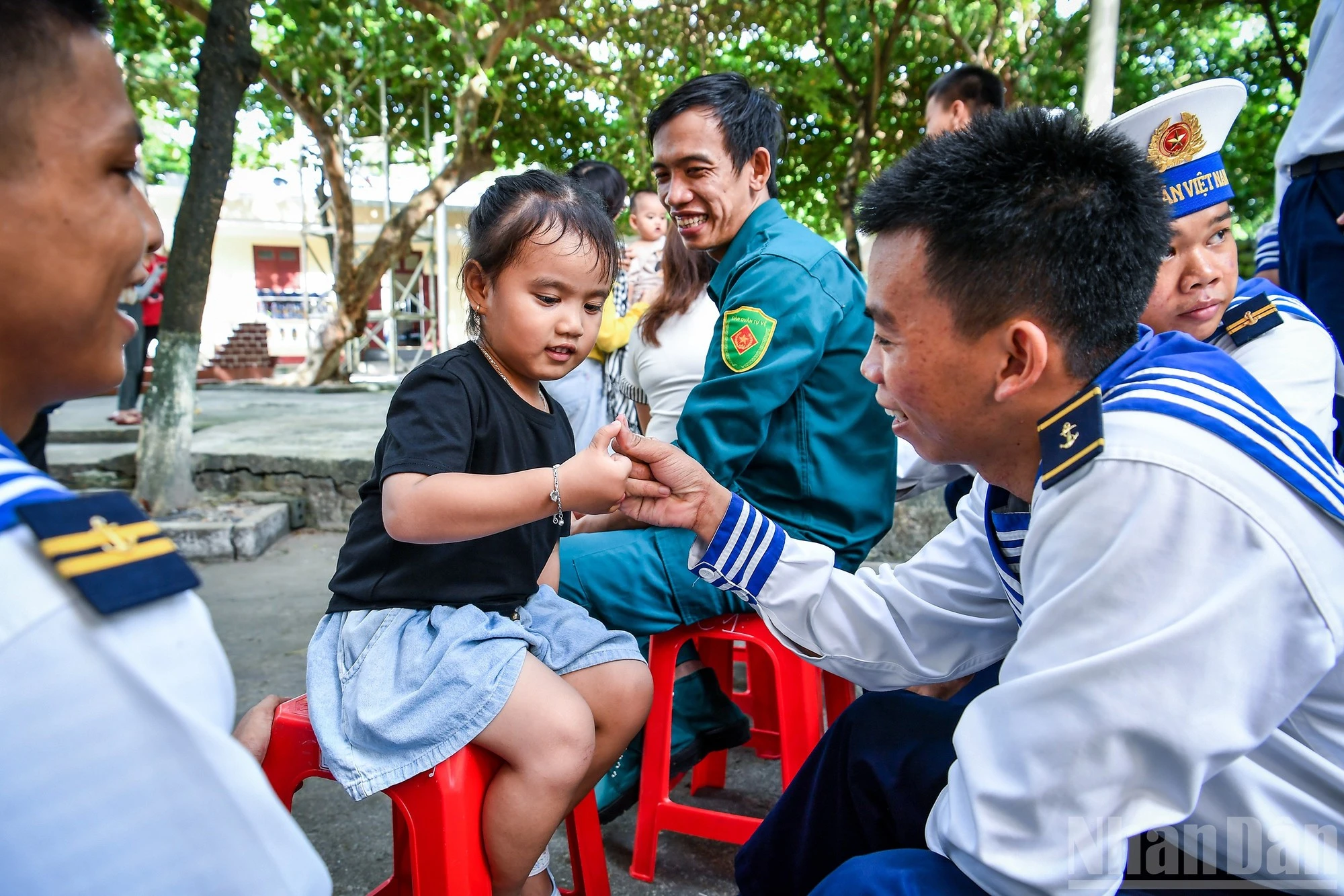 Lúc rảnh, những anh lính trẻ chơi đùa cùng các em bé trên đảo để vơi đi nỗi nhớ nhà.