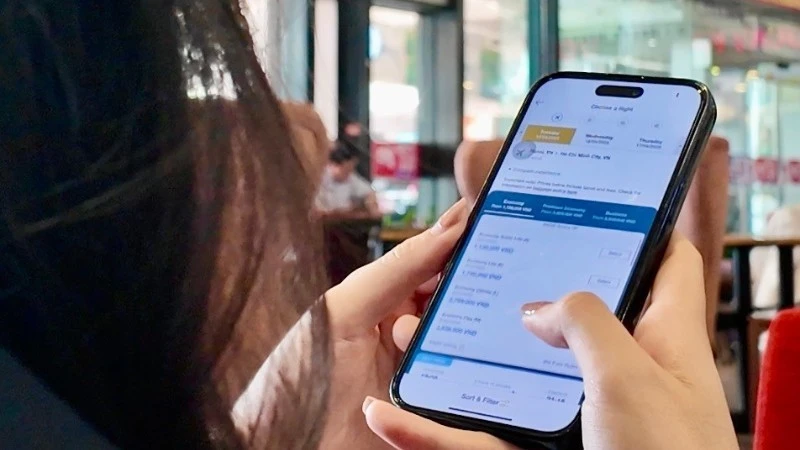 Hành khách làm thủ tục hàng không trực tuyến trước giờ khởi hành. (Ảnh: NGHĨA HƯNG)
