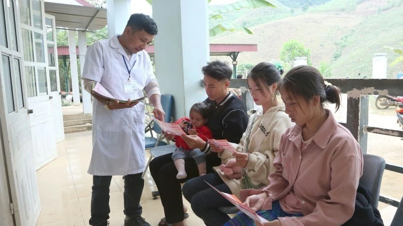Cán bộ Trạm Y tế Tân Xuân, xã Xuân Nha, tỉnh Sơn La, phát tờ rơi tuyên truyền về giảm thiểu mất cân bằng giới tính khi sinh.