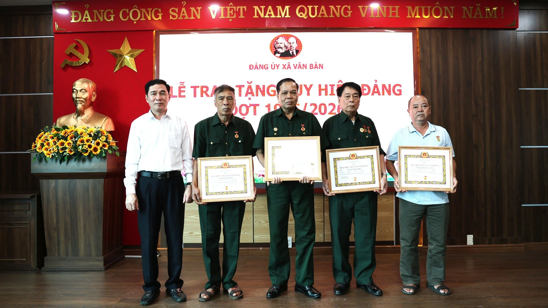 Đồng chí Nguyễn Minh Toàn và Thường trực Đảng ủy xã trao Huy hiệu Đảng cho đảng viên.