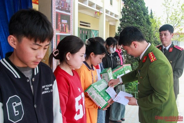 Đại úy Ngô Công Thắng, Trưởng Công an xã Tả Phìn trao quà cho các em học sinh.