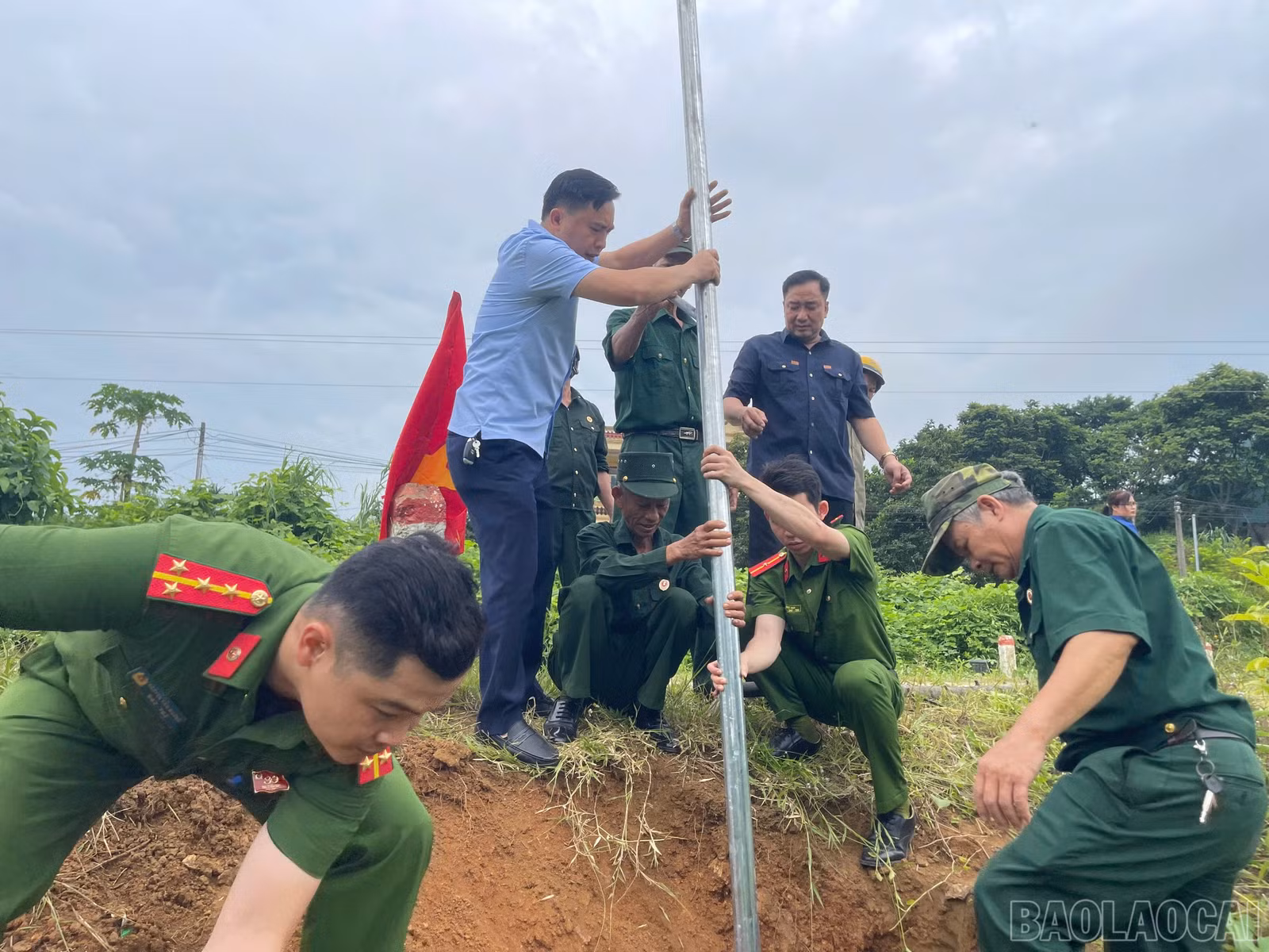 Các lực lượng tham gia dựng đèn năng lượng mặt trời trên tuyến đường tại thôn Liên Hà 5, xã Bảo Hà.