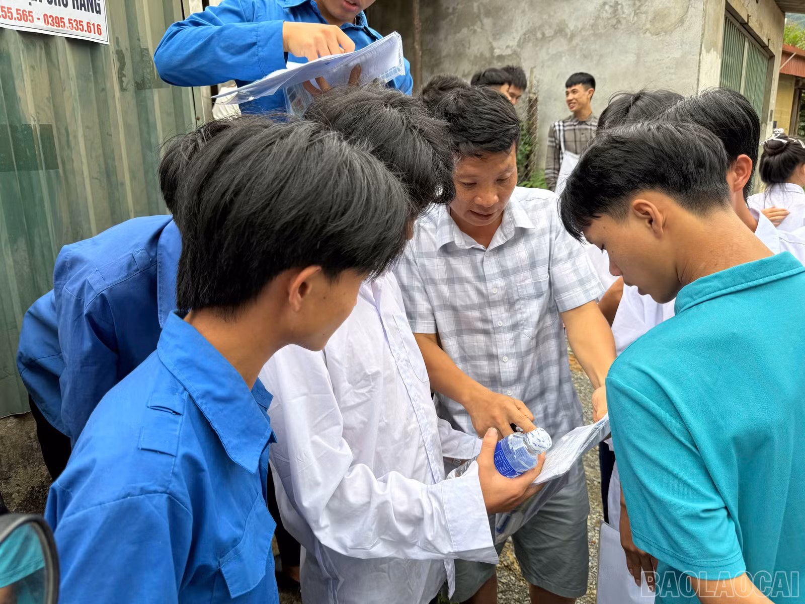 Thí sinh trao đổi đề thi với thầy giáo.