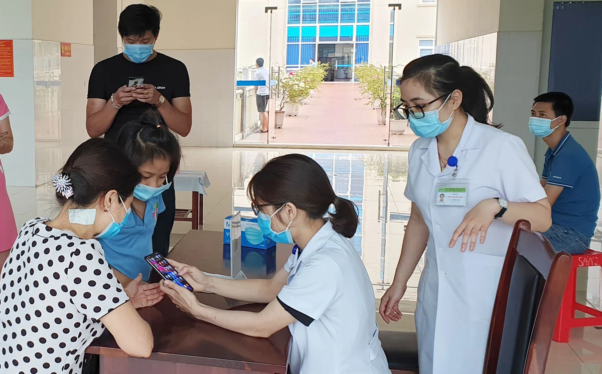 Các bác sỹ Bệnh viện Sản Nhi tỉnh Lào Cai hướng dẫn bệnh nhân khai báo y tế điện tử.