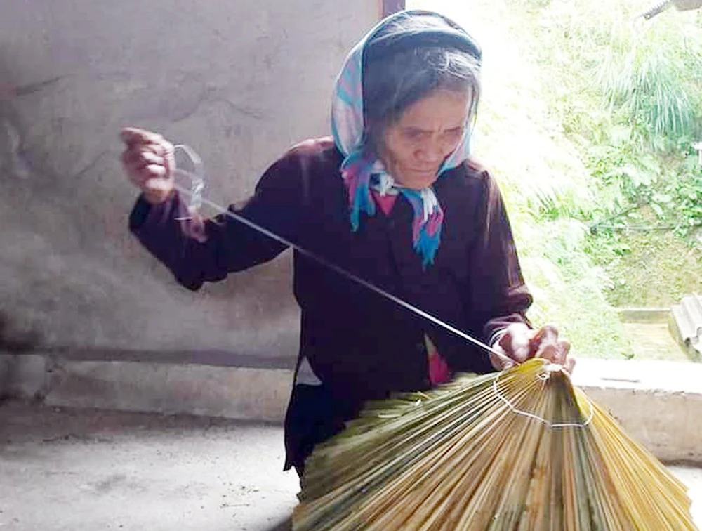 Bà Vàng Thị Tánh đan nón lá cọ.