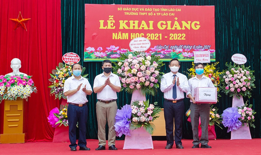 Chủ tịch Uỷ ban MTTQ Việt Nam tỉnh Lào Cai Giàng Seo Vần tặng lẵng hoa chúc mừng Trường THPT số 4 thành phố Lào Cai.