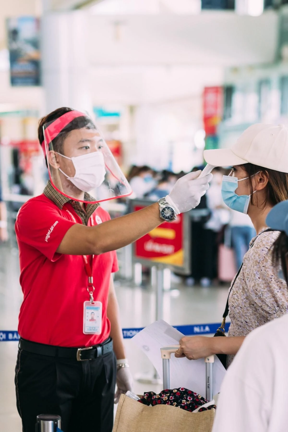 Kiểm tra thân nhiêt, phòng chống dịch COVID-19 cho khách đi máy bay.