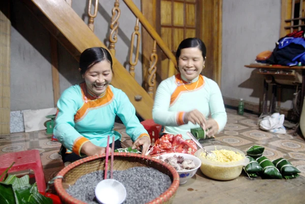 Giúp nhau gói bánh chưng ngày tết.