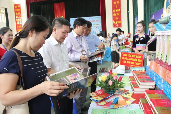 Các đại biểu thăm quan và đọc sách tại các gian trưng bày.