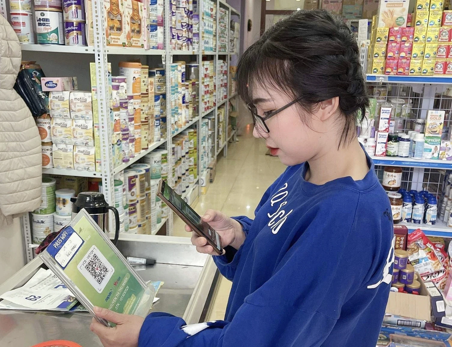 Khách hàng quét mã QR để thanh toán khi mua sắm tại chợ Nguyễn Du.