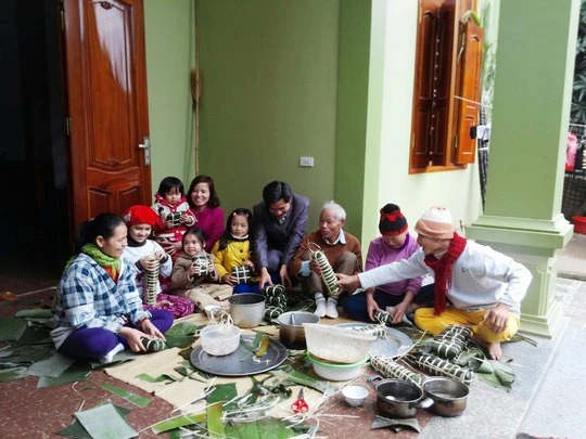Khoảnh khắc hạnh phúc khi nhiều thế hệ trong gia đình quây quần gói bánh chưng.