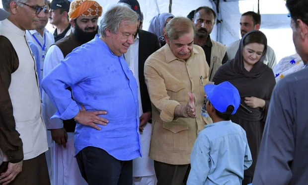 Tổng Thư ký Liên Hợp Quốc Antonio Guterres và Thủ tướng Pakistan Shehbaz Sharif (giữa) hỏi thăm một bé trai tại trại cứu trợ lũ lụt ở Jaffarabad.
