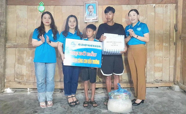 Lãnh đạo Hội Phụ nữ thị xã Sa Pa và Hội Phụ nữ xã Mường Bo tặng quà 2 anh em Lồ Quang Vĩnh và Lồ Đức Du.