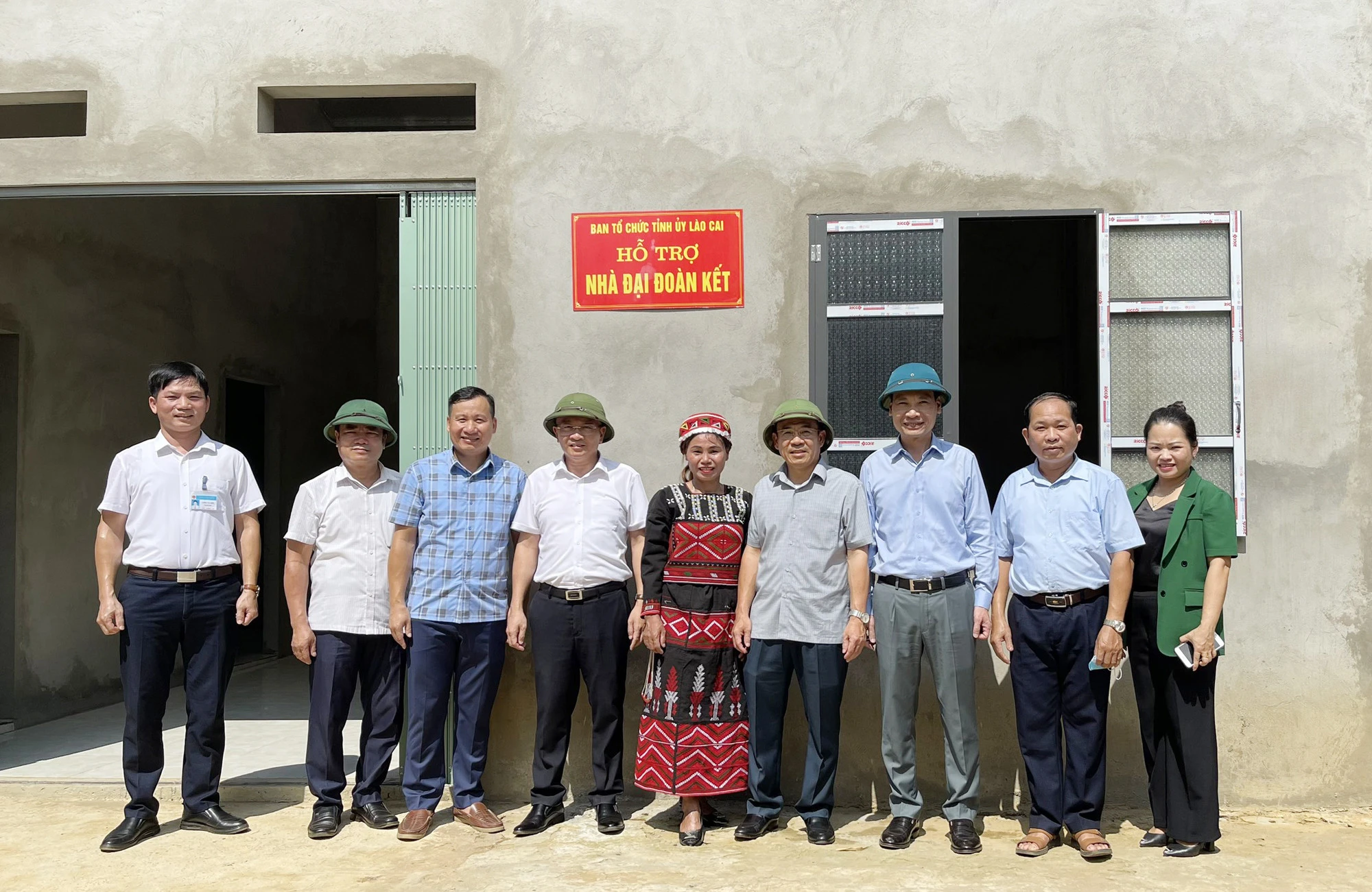 Các đại biểu bên ngôi nhà mới của gia đình bà Nông Thị Lá, thôn Ta Khuấn, xã Sơn Thủy.