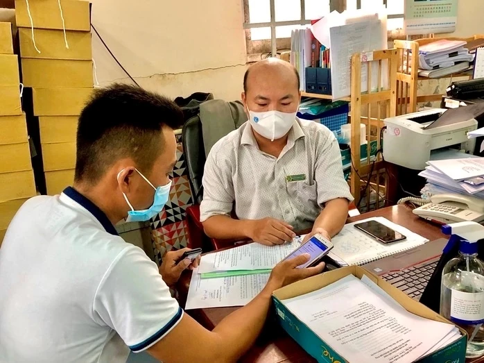 Người lao động được hướng dẫn nhận trợ cấp BHXH qua tài khoản. Ảnh: Báo điện tử ĐCSVN