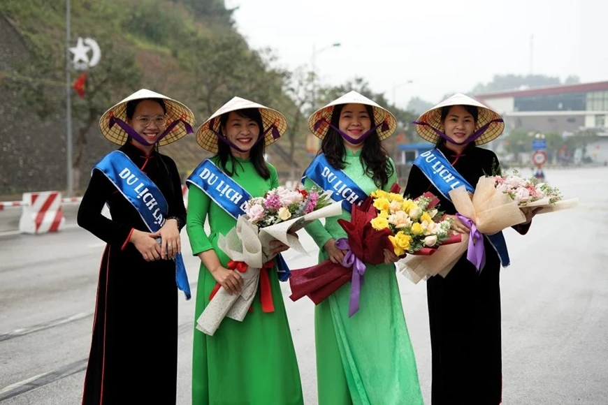 Ngày 15-3-2023, các cô gái Việt Nam tay cầm hoa tươi chào đón du khách Trung Quốc tại Cửa khẩu quốc tế Hữu Nghị (Lạng Sơn, Việt Nam).