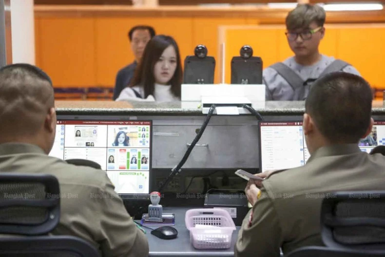 Cảnh sát vận hành hệ thống nhận dạng sinh trắc học tại trạm kiểm soát xuất nhập cảnh sân bay Don Mueang, Thái Lan.