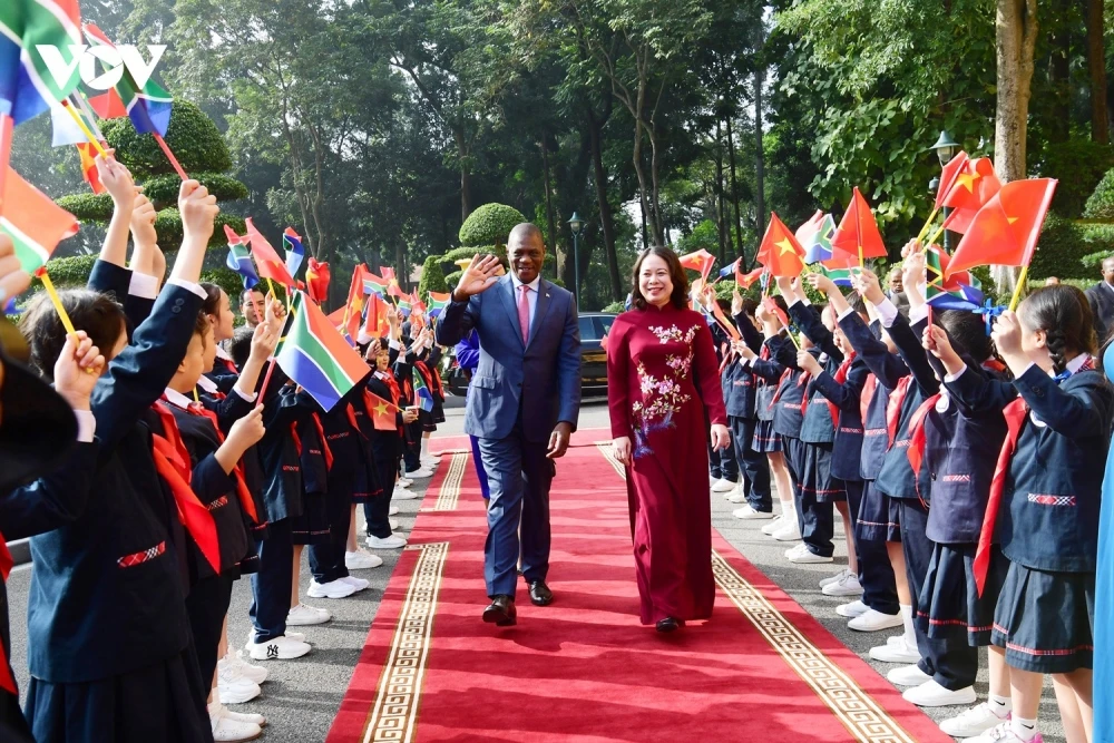 Các em thiếu nhi vẫy cờ chào đón Phó Chủ tịch nước Võ Thị Ánh Xuân và Phó Tổng thống Nam Phi Paul Mashatile.