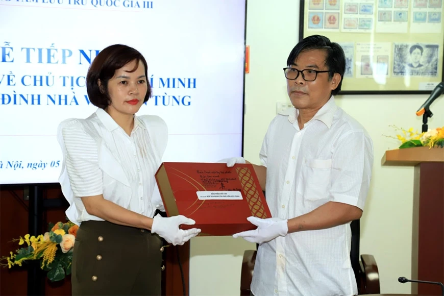 Con trai nhà văn Sơn Tùng trao tặng tài liệu cho đại diện Trung tâm Lưu trữ quốc gia III. Ảnh: Hồng L.