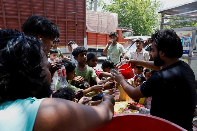Người dân uống nước giải nhiệt trong ngày hè nóng bức ở thủ đô New Delhi - Ấn Độ hôm 29/5.