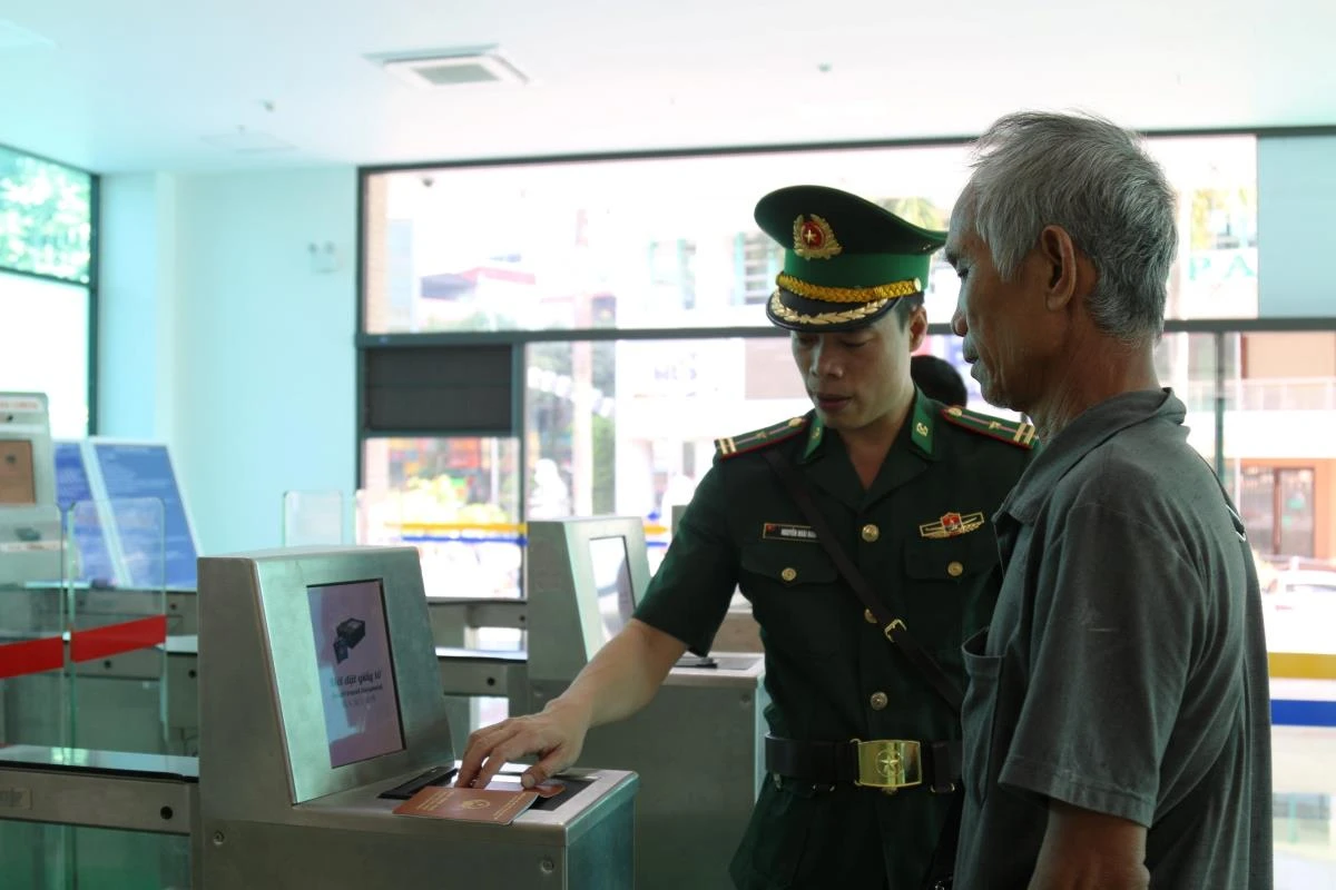 Cán bộ BĐBP Lào Cai hỗ trợ hành khách làm thủ tục xuất cảnh tại cổng kiểm soát tự động.